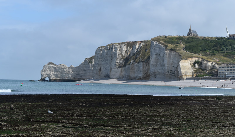 Loi littoral - Plage d'Étretat, face à la falaise droite, lors d'une journée ensoleillée.